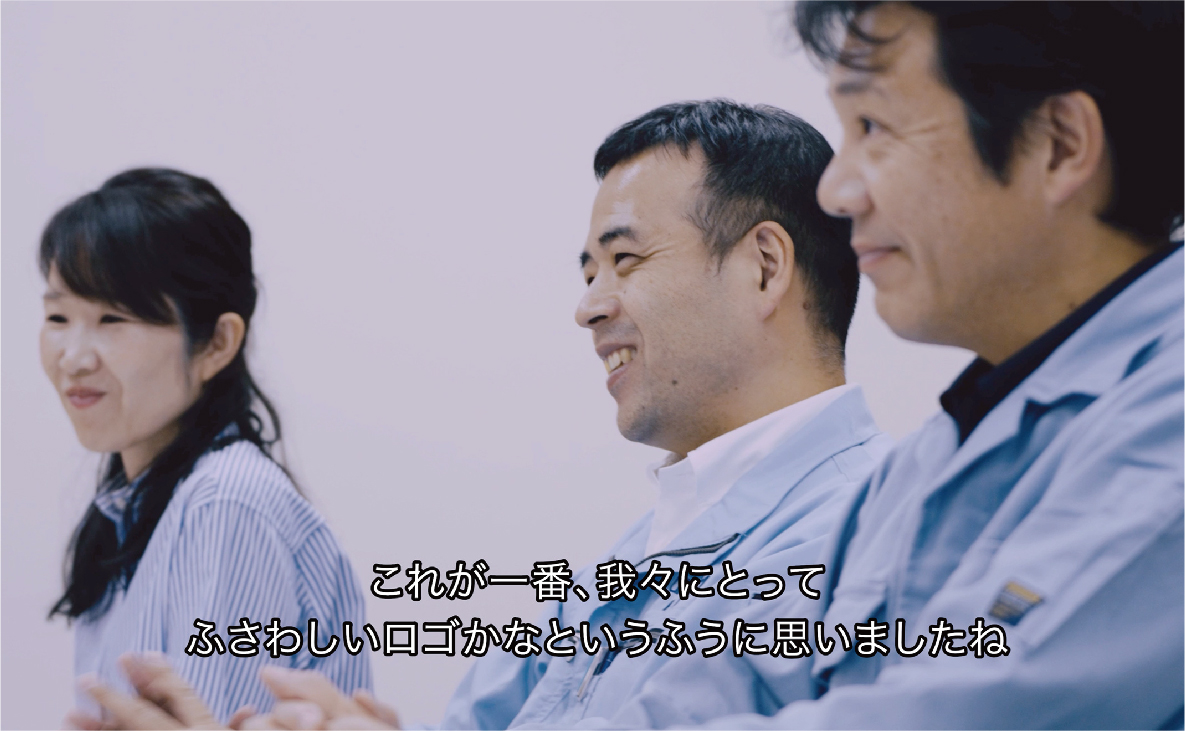 動画の一場面のスクリーンショット。手前から奥に3名並び微笑んでいる。